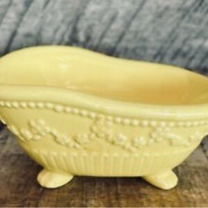 Vintage butter yellow ceramic soap dish shaped like bathtub.